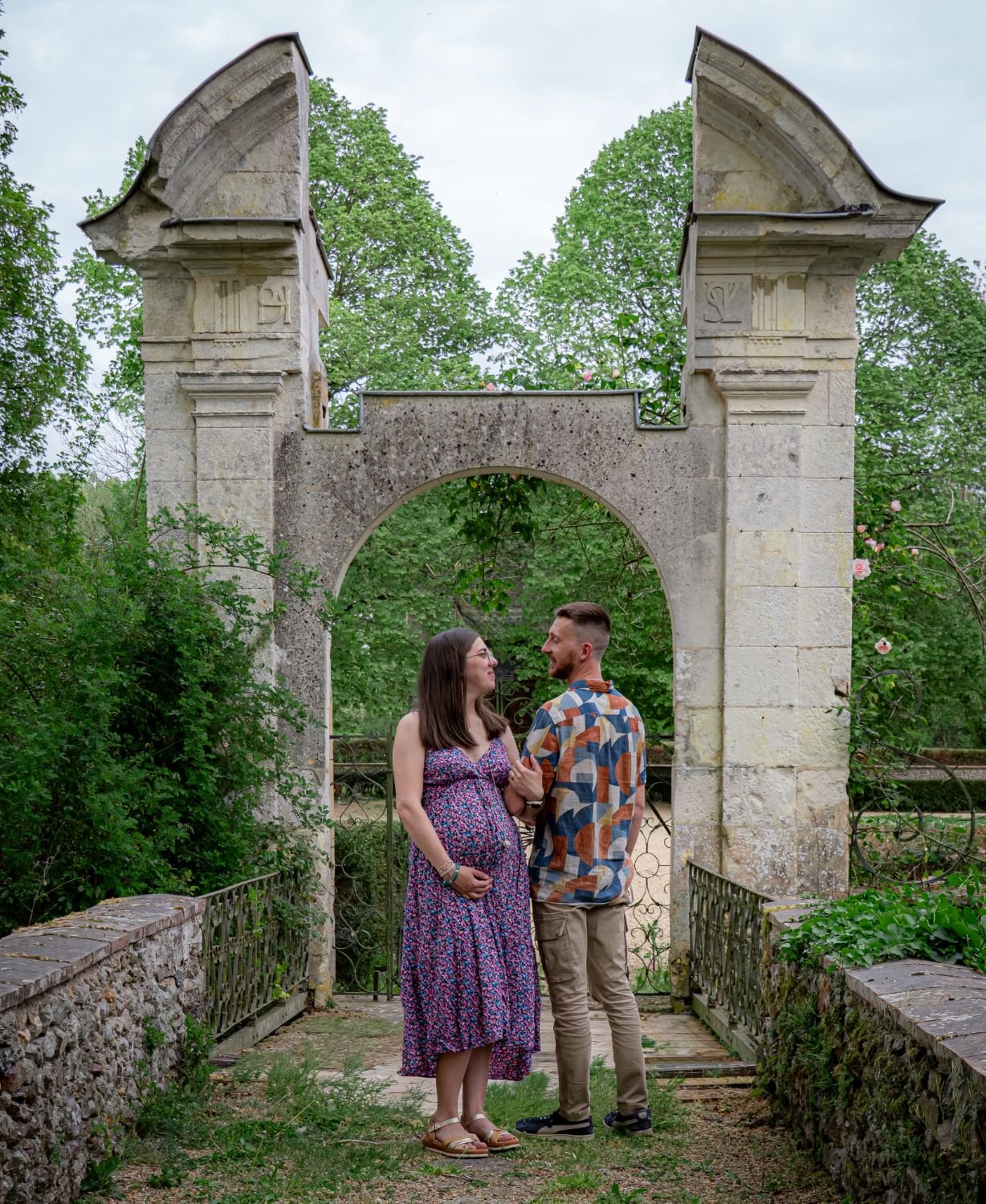 Couple attendant un enfant sous une arche de pierre