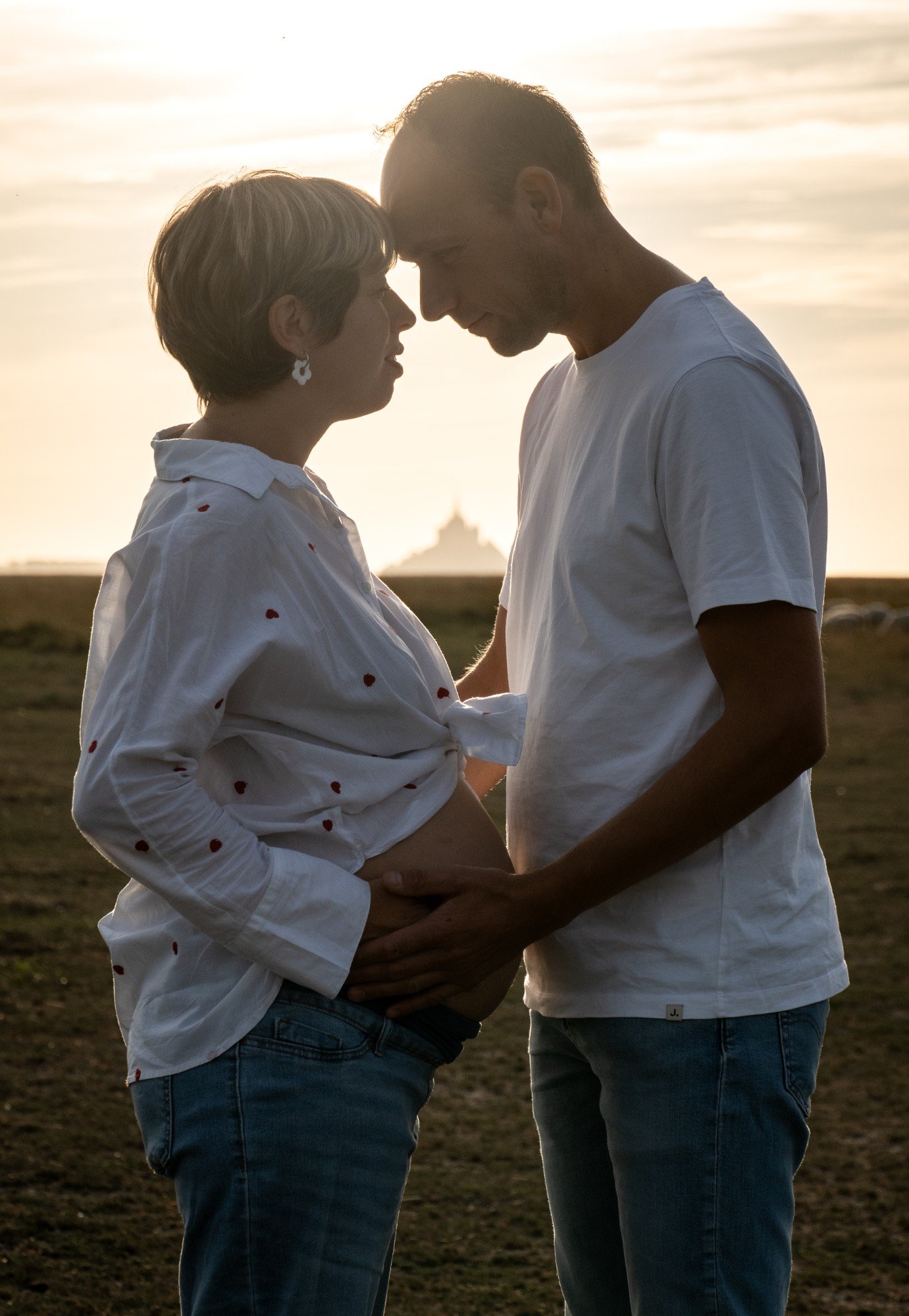 Futurs parents front contre front au coucher du soleil, le Mont au loin